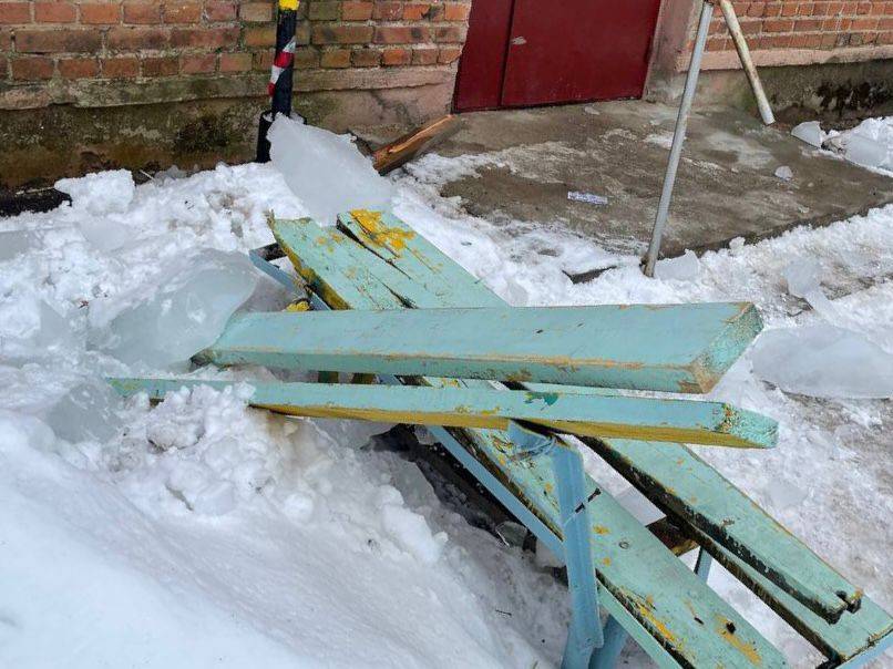 Очередная глыба льда упала с крыши жилого дома и сломала две скамейки 