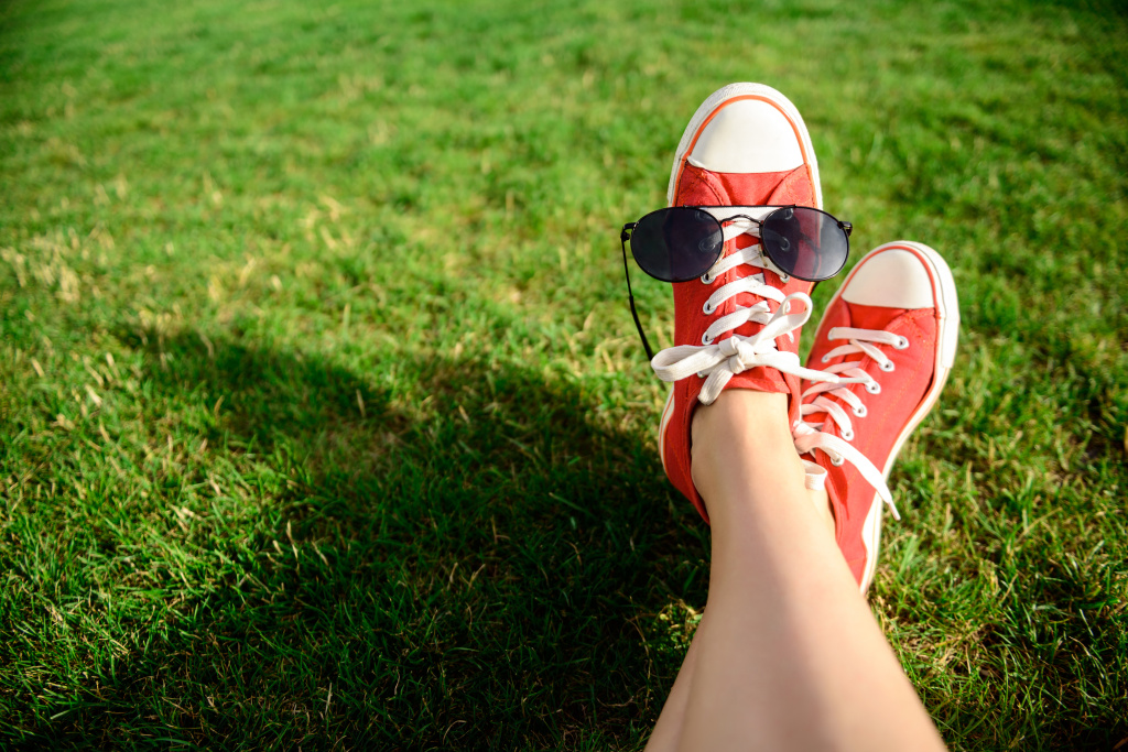 close-up-of-legs-in-red-keds-lying-on-grass.jpg