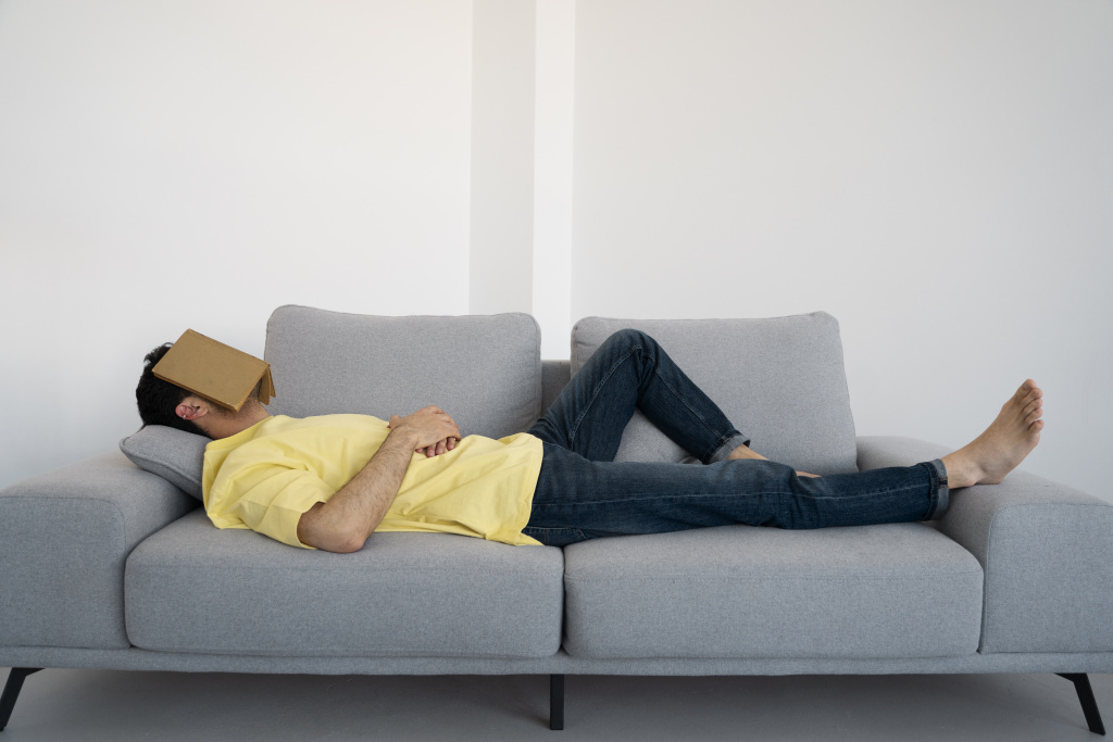 full-shot-man-laying-on-couch-with-book.jpg